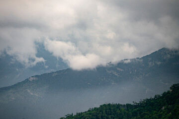 Fototapeta premium heavy huge rainy clouds sky, above the mountain settlement village