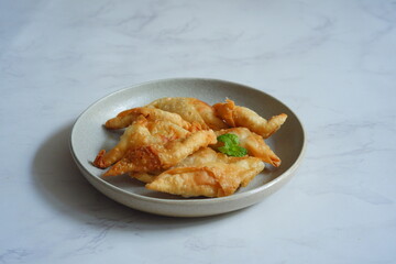 a plate of fried banana pastry named molen pisang 