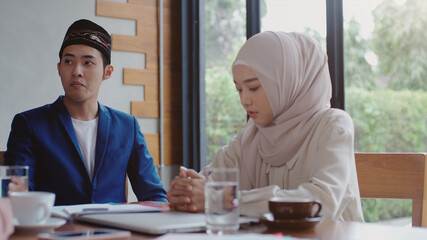 Upwardly mobile Asian Muslim business entrepreneur SME start up group of young man and women, discussing sale and marketing analysis, Asian Muslim SME teamwork e-commerce concept