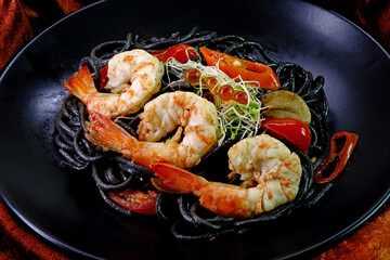 Squid ink spaghetti with prawn. Italian  food. Selective focus, top view