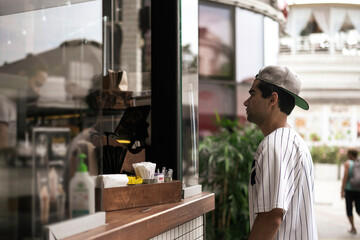 person buying food and coffee in city street cafe