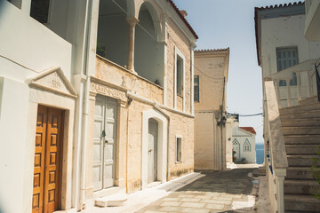 Fototapeta na wymiar Beautiful street in city Chora on Andros island, Cyclades, Greece in summer sunny day