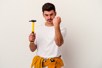 Young caucasian worker man with tools isolated on white background showing fist to camera,...