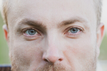 Fototapeta premium Blue eyes of a man close up.