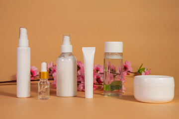 Copy space geometric shapes with night, day cream cosmetic oil, eye cream on yellow background. Unbranded bottles in mockup style. Beauty background with facial cosmetic products. Spa, beauty concept.