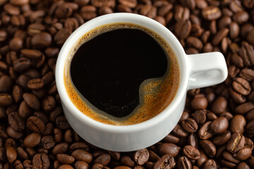 Steaming espresso served in cup on dark