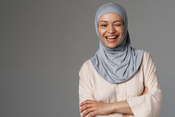 Middle eastern woman in hijab smiling and winking at camera