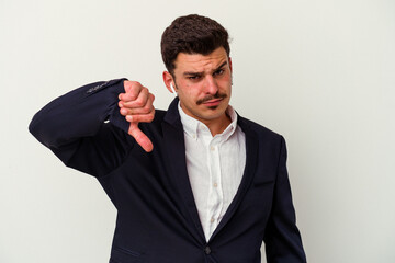 Young business caucasian man wearing wireless headphones isolated on white background showing a dislike gesture, thumbs down. Disagreement concept.