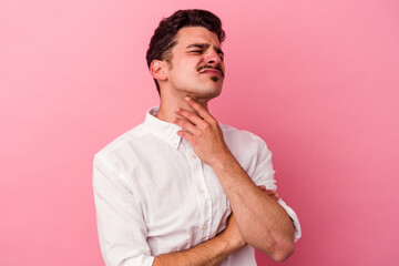 Young caucasian man isolated on pink background suffers pain in throat due a virus or infection.