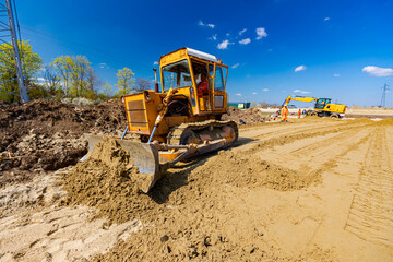 Obraz premium Bulldozer machine is leveling construction site.