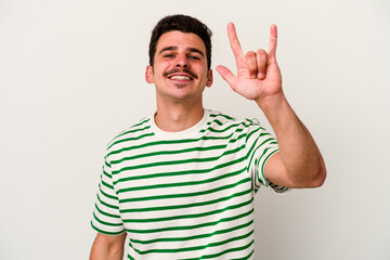 Fototapeta premium Young caucasian man isolated on white background showing a horns gesture as a revolution concept.