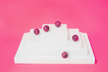 various pink basketballs on various structures on pink background. sport and competition.copy space.