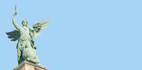 Banner with top roof statue of sensual renaissance era angel with wings in Vienna, Austria, with copy space blue sky solid background. Concept of historical architecture heritage.