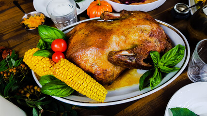 a festive dish with goose for a traditional family dinner in honor of the Thanksgiving holiday. table with pumpkins and autumn seasonal dishes.