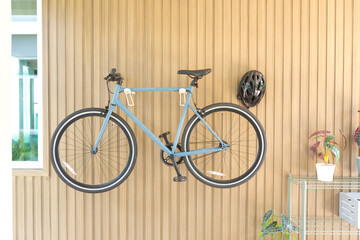 Bicycle hanged on wooden wall at house.