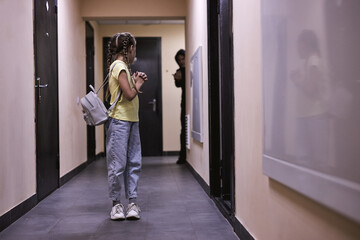 Dangerous adult man spying on entrance. space for text. Child in danger. frightened caucasian child girl is alone indoors, having no help. child abuse, pedophilia, maniac, violence, crime concept
