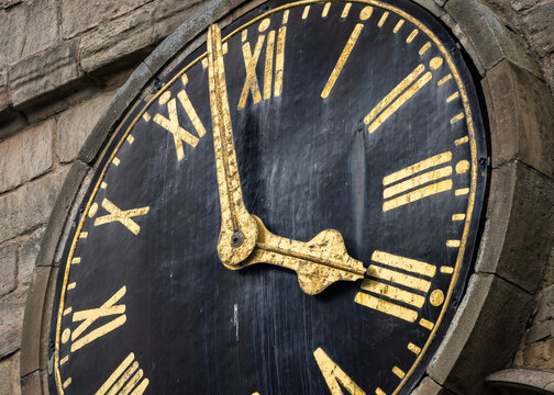 Vintage old church clock face of chesterfield crooked spire with gold leaf roman numerals four o'clock time