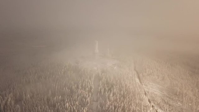 Dlog Drone view of the Feldberg Taunus Schmitten area during a cold winter day. Trees covered in snow and ice. Forrest in snow. Filmed during sunrise. Snow is wonderfully coloured in orange and red.