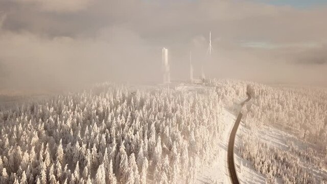 Dlog Drone view of the Feldberg Taunus Schmitten area during a cold winter day. Trees covered in snow and ice. Forrest in snow. Filmed during sunrise. Snow is wonderfully coloured in orange and red.