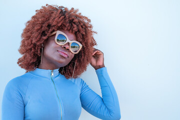 Retrato de chica afro tocándose el pelo en fondo blanco con espacio par texto.