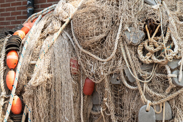 Different fishing nets hang to dry against the wall on the quay.