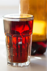 Close up glass with kvass beverage and bottle in summer time