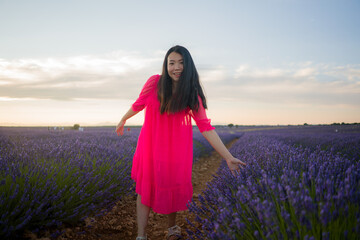 young happy and beautiful Asian Japanese woman in Summer dress enjoying nature free and playful outdoors at purple lavender flowers field in romantic beauty concept