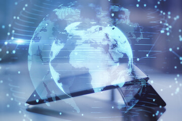 Close up of tablet with abstract globe interface on blurry desktop background. International communication and business concept. Double exposure.
