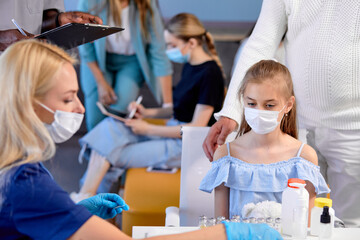 Cute Child Girl Is Looking Brave Before Vaccination In Hospital, Portrait of Doctor And Patient,...