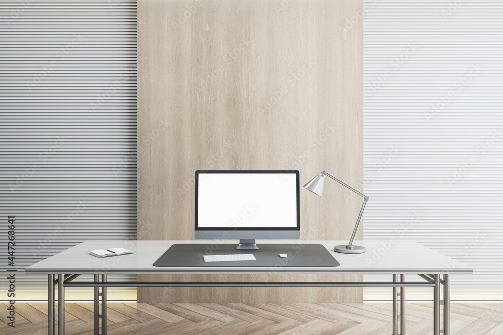 Poster desk with empty computer monitor in modern white office interior with daylight and wooden flooring. 