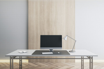 Desk with empty black computer monitor in modern white office interior with daylight and wooden flooring. Mock up, 3D Rendering.