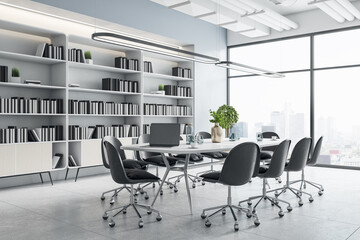 Sunny spacious meeting hall with big library with books, white table surrounded by black chairs on concrete floor and city view from big window