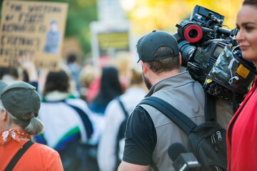 Australian television news crew broadcasting from a climate change protest outdoors