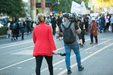 Australian television news crew broadcasting from a climate change protest outdoors