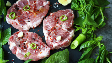 Raw meat steaks with spices and basil. Pork steaks.