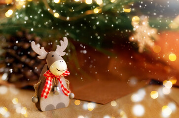 Christmas composition with holiday elk decoration.Burning lantern and christmas decoration on brown background,copy space