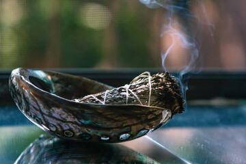 Burning sage up close in natural light with smoke in the frame 