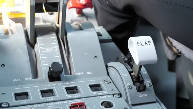 Pilot In The Cockpit Setting Flap Lever Of An Airplane Into 22 Degrees. close up