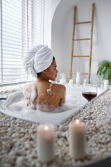 Seductive woman relax in a bubble bath, back view