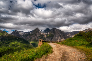 Fototapeta na wymiar path in the mountains with storm clouds in the sky