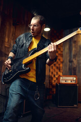 Obraz premium Brutal musician with electric guitar on stage