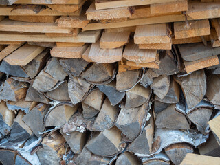 Firewood from boards and birch logs stacked in a woodpile