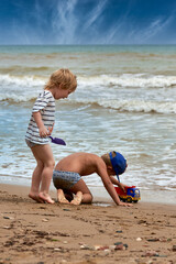 Fototapeta na wymiar Two little boys are playing on the seashore