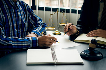 Businessman and lawyer discussing contract documents sitting at a table Legal ideas, advice,...