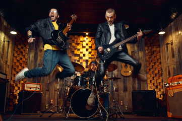 Fototapeta na wymiar Two brutal musicians jumps with electric guitars