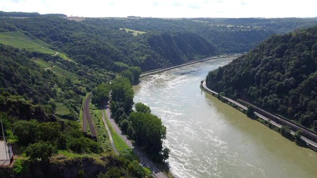 Video from a drone flying above the Rhine river in Germany, visible road on both sides of the river.