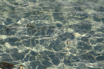 Surface of clear transparent water texture in fountain or pool on a sunny summer day with...