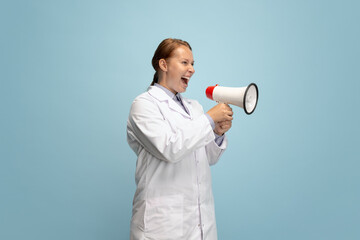 One female doctor, therapeutic or medical advisor shouting at megaphone isolated on blue...