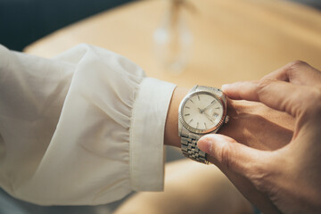 fashionable wearing stylish looking at luxury watch on hand check the time .concept for managing...
