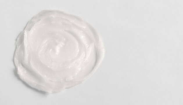 The texture of the lip balm. Transparent ointment on a white background and copy space